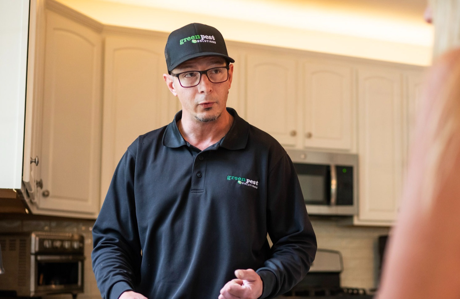 pest control tech in kitchen with customer