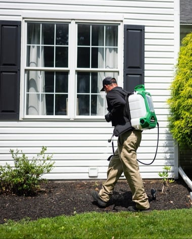 pest technician outside of a home