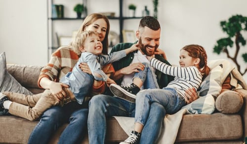 happy-family-mother-father-and-kids-at-home-on-couch-stockpack-adobe-stock-768x449